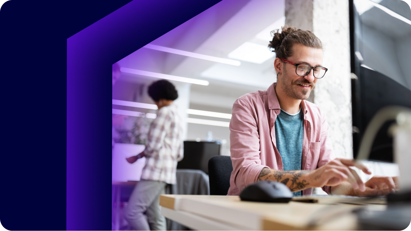 Photo of happy male employee at computer